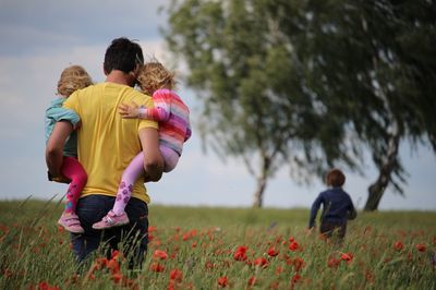 Padre con niños paseando por el prado